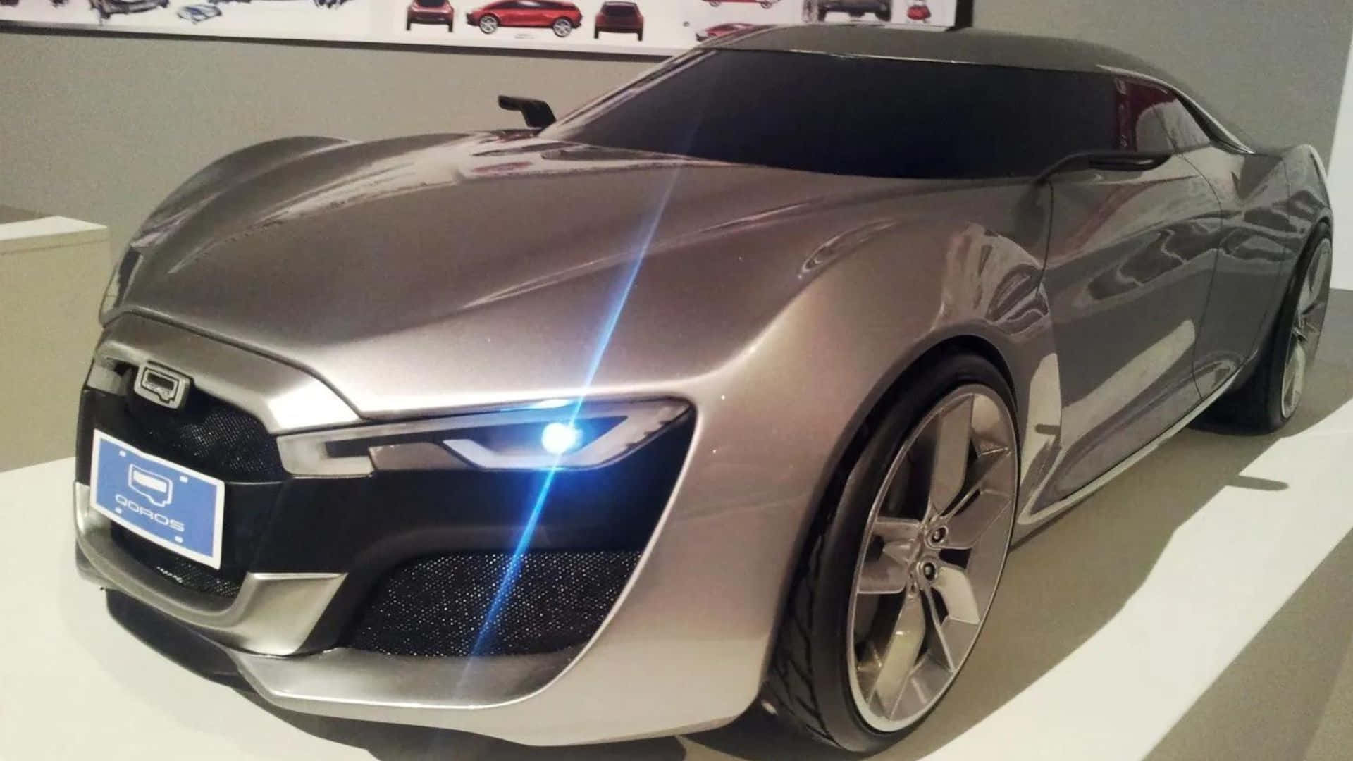 Qoros 桌布 壁紙 — 一架時尚的銀色未來感跑車，配備發光藍色車頭燈，在現代展廳的白色平台上展示。