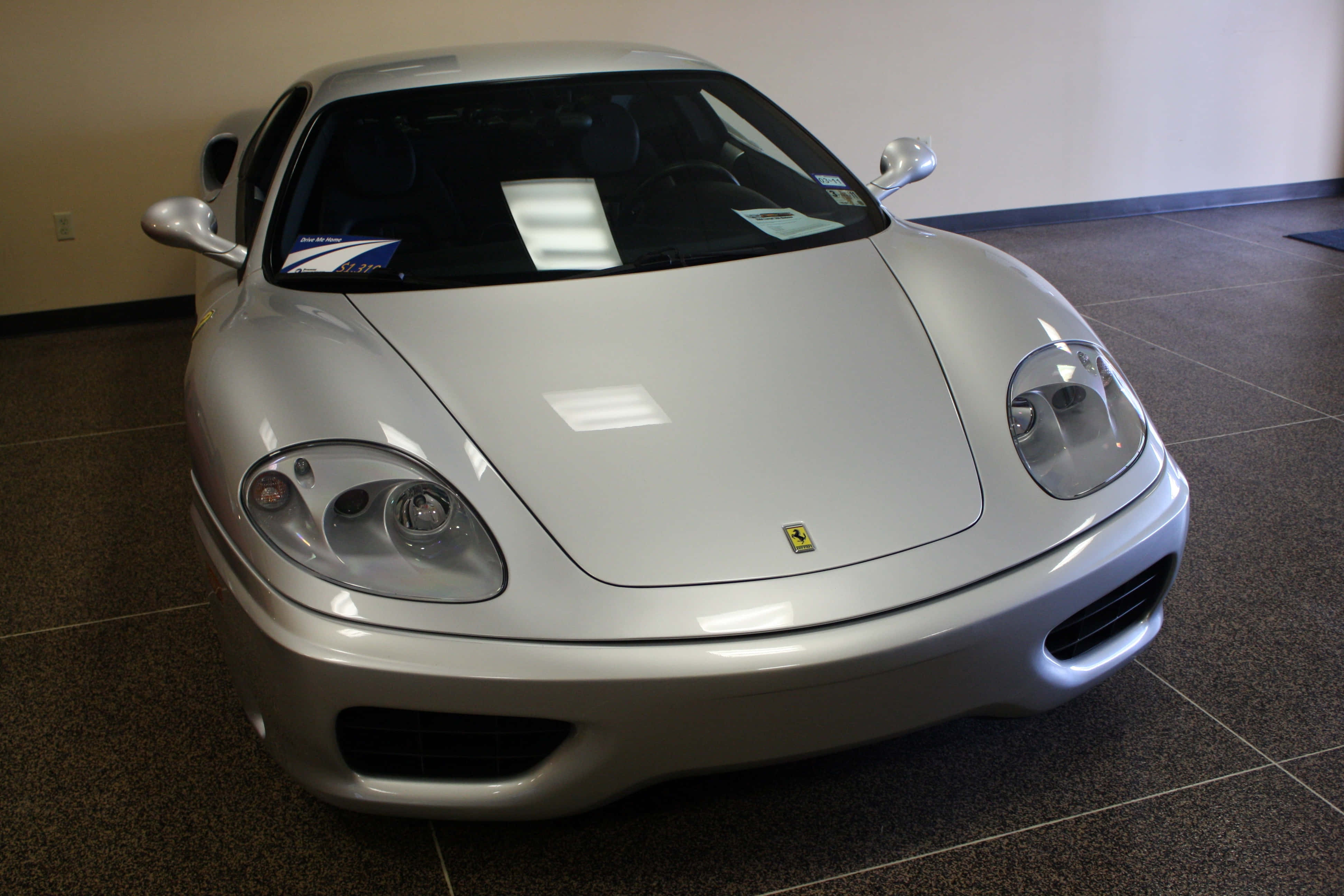 Ferrari 360 Modena 桌布 壁紙 — 一架時尚的銀色法拉利跑車在室內明亮的燈光下，在瓷磚地板上閃閃發光。