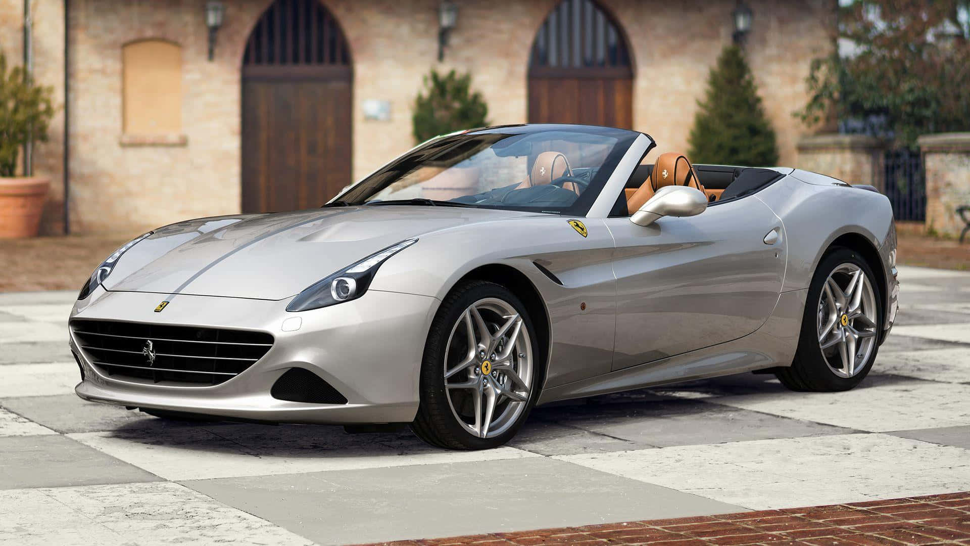 Ferrari California T 桌布 壁紙 — 一架時尚的銀色法拉利開篷車停泊在棋盤花紋的石頭車道上，前面是一座質樸的磚砌別墅。