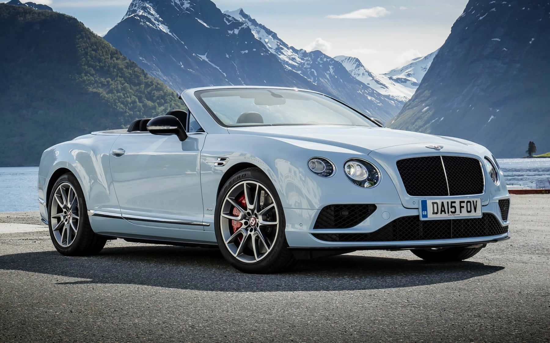 Bentley Continental Gt 桌布 壁紙 — 一架時尚的銀色賓利開篷車停泊在湖邊道路上，背景是白雪覆蓋的山脈。