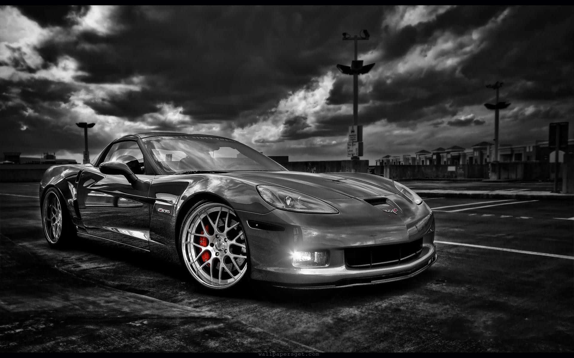 Black And White Car 桌布 壁紙 — 一架時尚的銀色跑車配備紅色制動卡鉗，停泊在荒涼的停車場，背景是戲劇性的暴風雨天空。