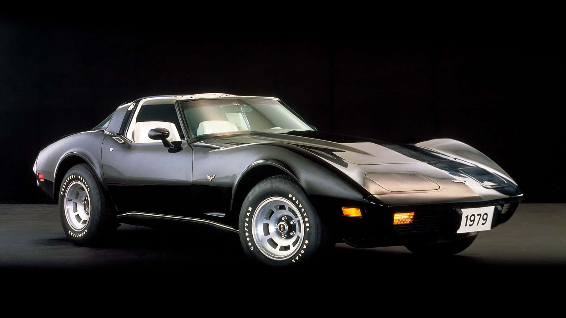 classic 桌布 壁紙 — 一架時尚的黑色1979年雪佛蘭Corvette跑車，配備白色內飾和銀色輪圈，在深色工作室背景下擺拍。