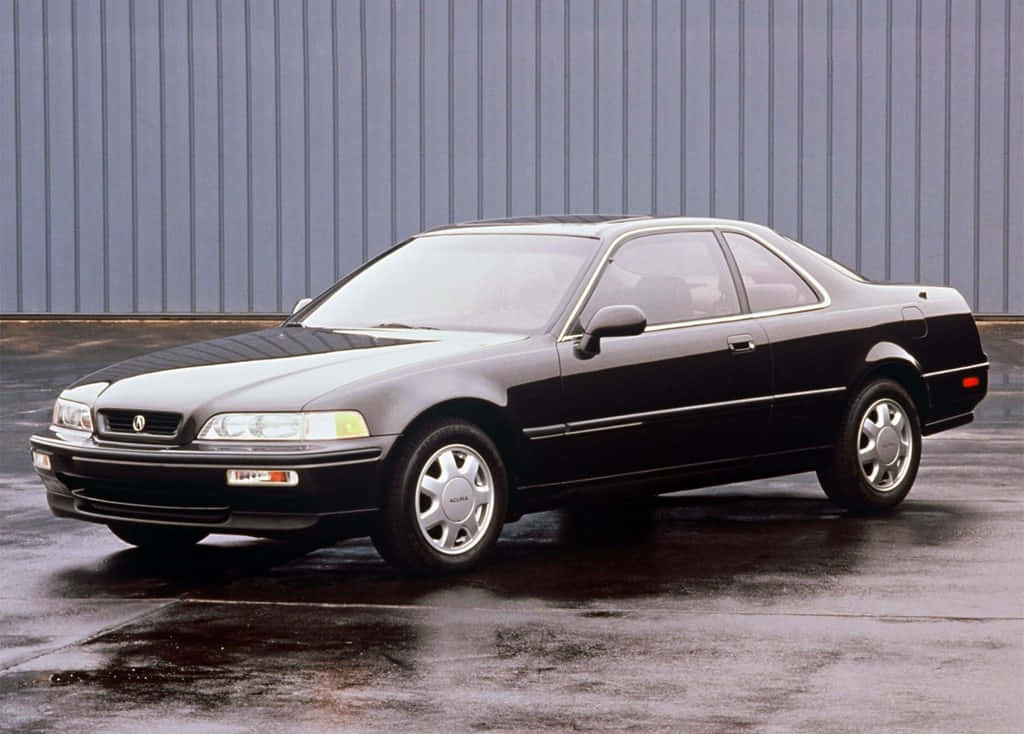 Acura Legend 桌布 壁紙 — 一架時尚的黑色Acura NSX雙門跑車停泊在濕漉漉的路面上，背景是灰色波紋金屬牆。