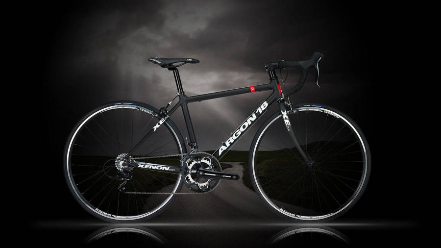 桌布 壁紙 — 一架時尚的黑色Xenon Argon 18公路單車，在黑暗暴風雨的天空和反射地面的襯托下，顯得格外突出。