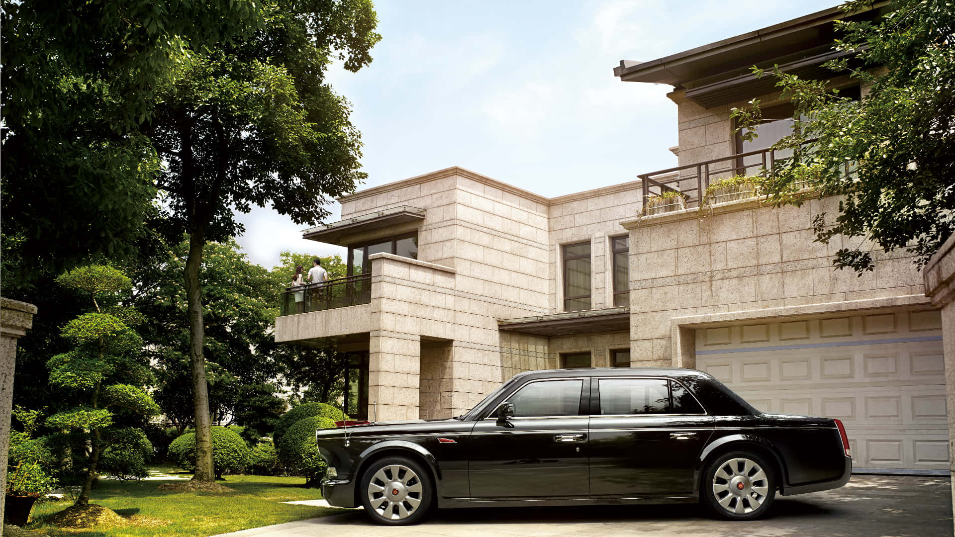 Hongqi 桌布 壁紙 — 一架時尚的黑色勞斯萊斯幻影停泊在一座現代石砌豪宅前，周圍環繞著茂密的綠植，天空明亮。