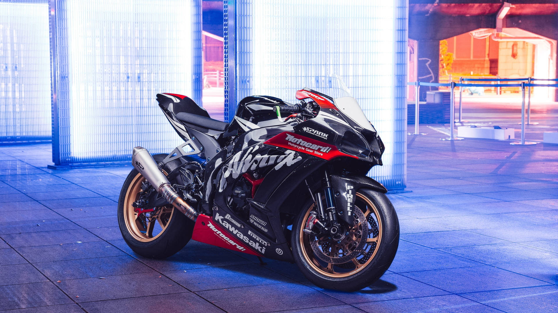 機車 桌布 壁紙 — 一架時尚的黑色和紅色Kawasaki Ninja運動電單車在現代都市環境中，在充滿活力的藍色霓虹燈下閃閃發光。