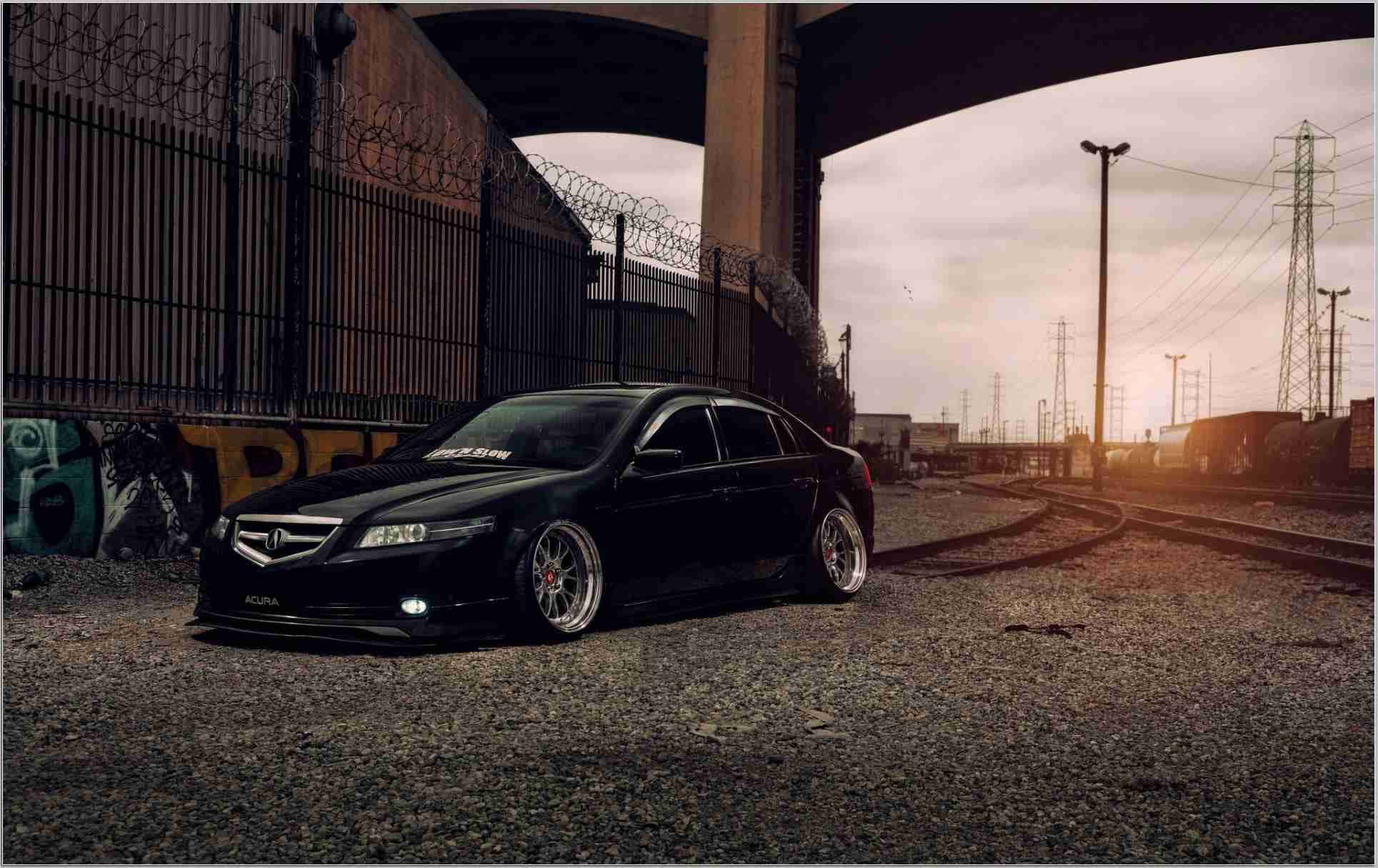 Acura Tl 桌布 壁紙 — 一架時尚的黑色改裝房車停泊在天橋下，旁邊是塗鴉牆和火車軌道，正值黃金時段。