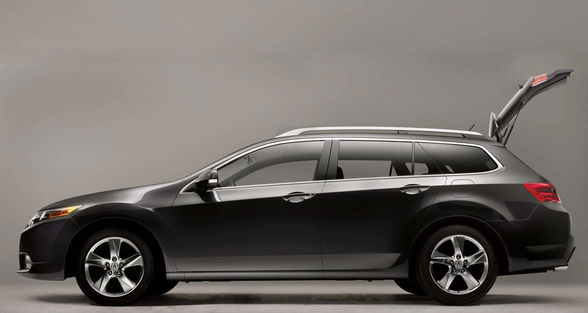 Acura Tsx 桌布 壁紙 — 一架時尚的黑色旅行車，尾門打開，在簡約的工作室中，背景為中性灰色。