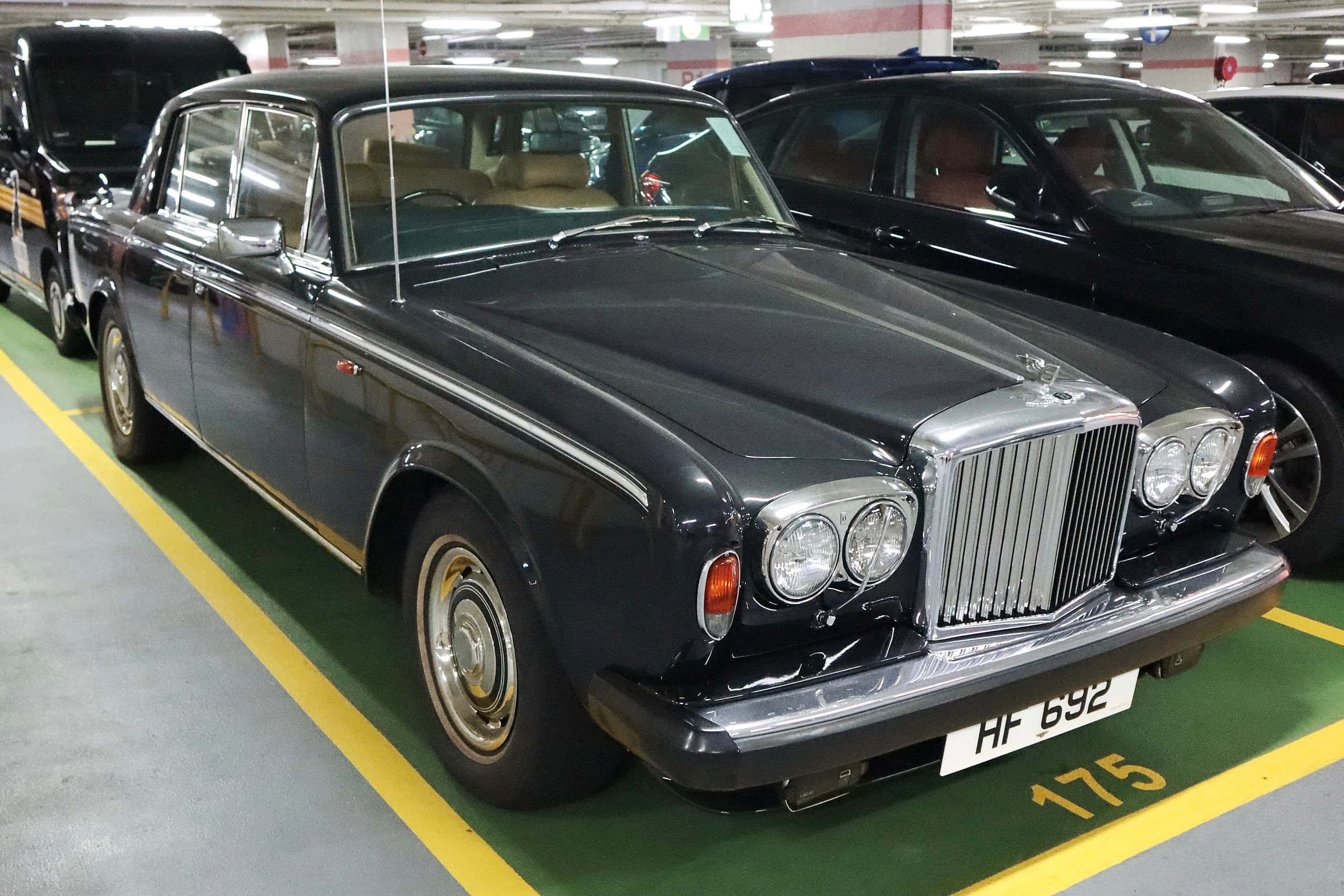 Bentley T2 桌布 壁紙 — 一架時尚的黑色賓利S1停泊在光線充足、帶有黃色停車線的地下停車場。