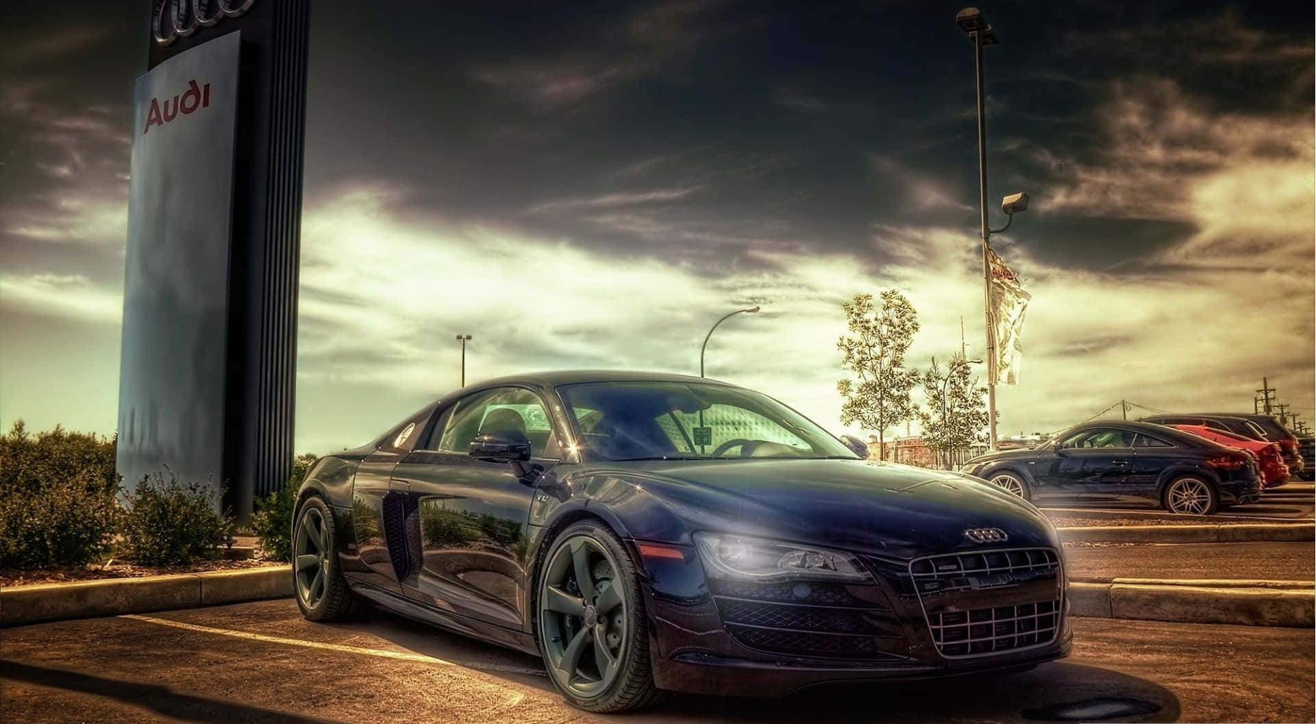 4K Hdr 桌布 壁紙 — 一架時尚黑色奧迪R8跑車在經銷商停車場中，在戲劇性的金色日落光線下閃閃發光。