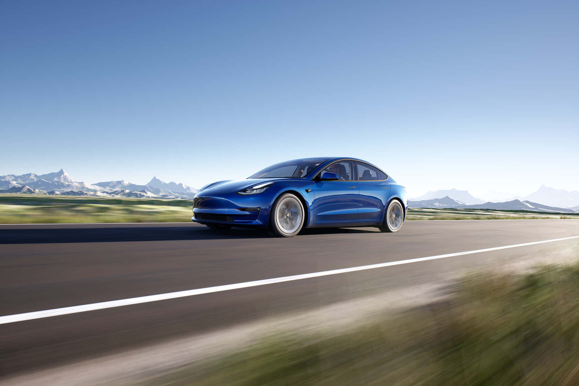 tesla 桌布 壁紙 — 一架流線型藍色Tesla Model 3在晴朗藍天下沿著蜿蜒的山路行駛，山峰白雪皚皚。