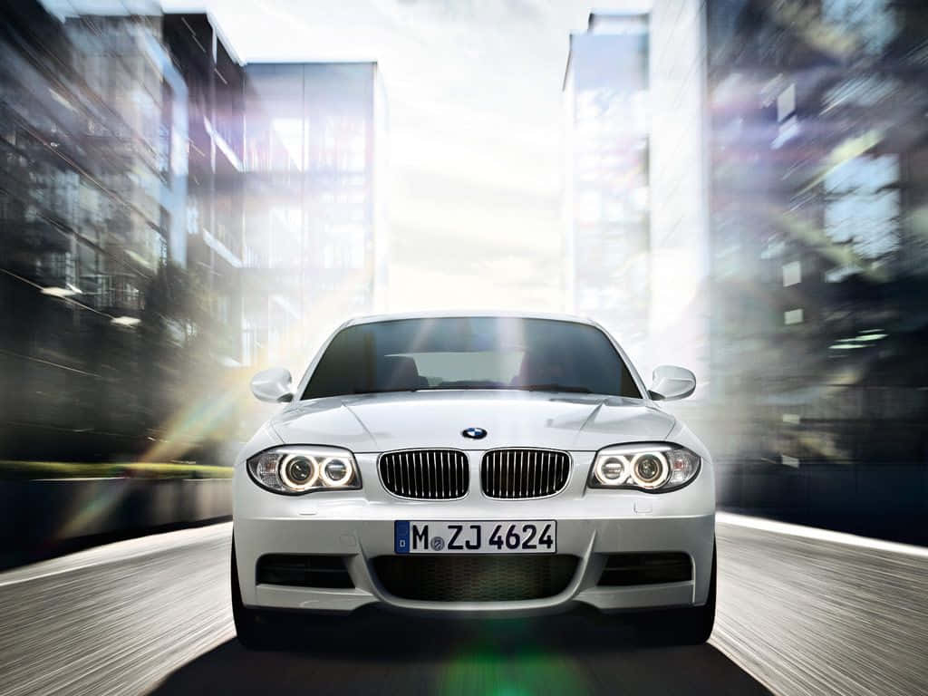 Bmw 1 Series 桌布 壁紙 — 一架流線型銀色寶馬在模糊的城市峽谷中疾馳，帶有動態條紋和明亮的鏡頭光暈。