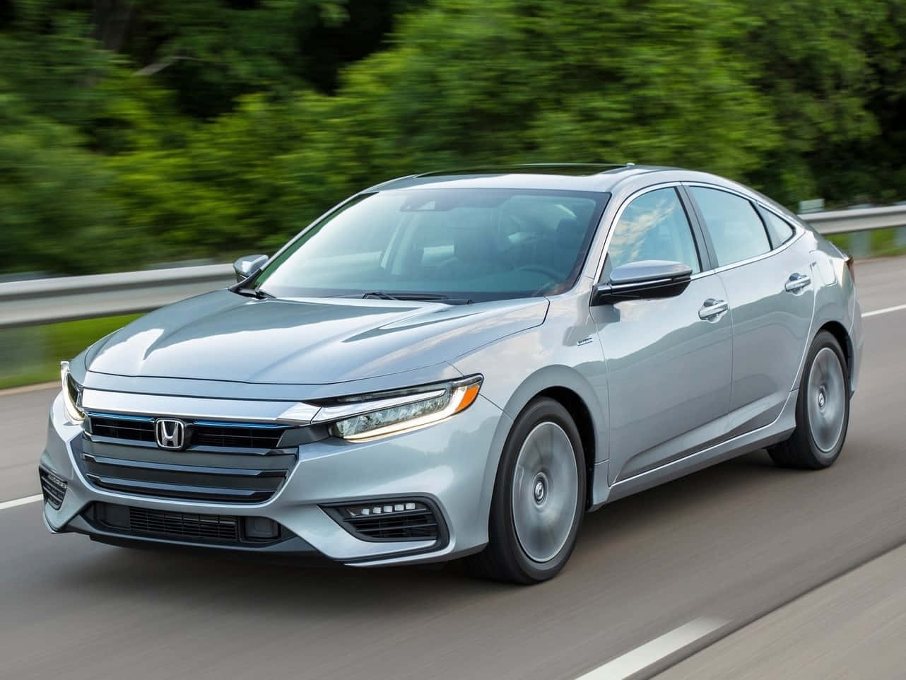 Honda Insight 桌布 壁紙 — 一架流線型銀色本田房車在高速公路上飛馳，背景中翠綠的樹木模糊成一片。