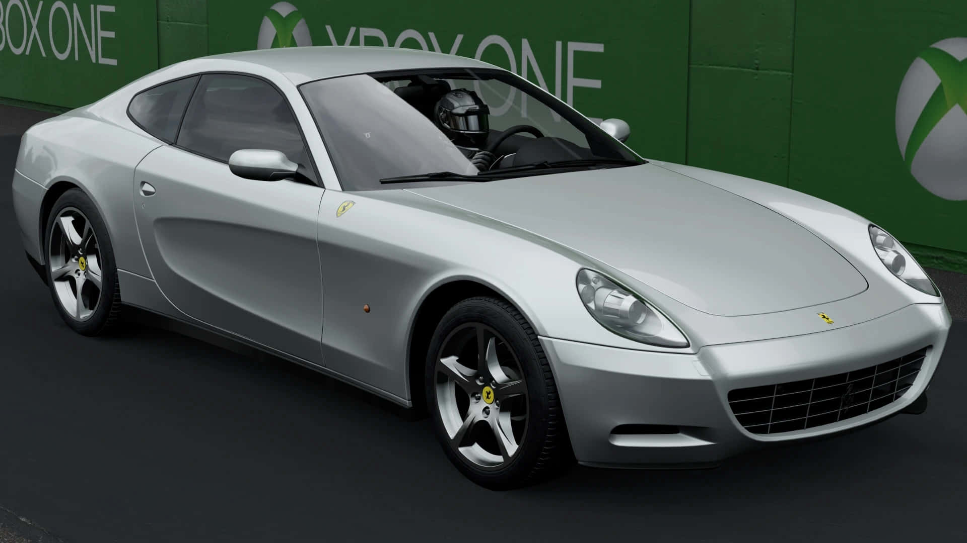 Ferrari 612 Scaglietti 桌布 壁紙 — 一架流線型銀色法拉利跑車，司機戴著頭盔，停泊在綠色Xbox One品牌牆前。