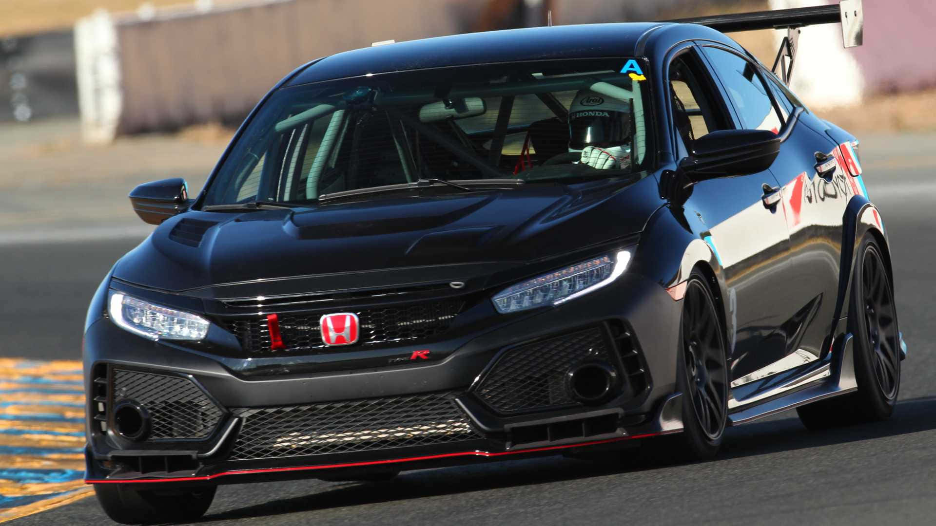 Hatchback 桌布 壁紙 — 一架流線型黑色本田思域Type R賽車在賽道上飛馳，透過擋風玻璃可以看到戴著頭盔的車手。