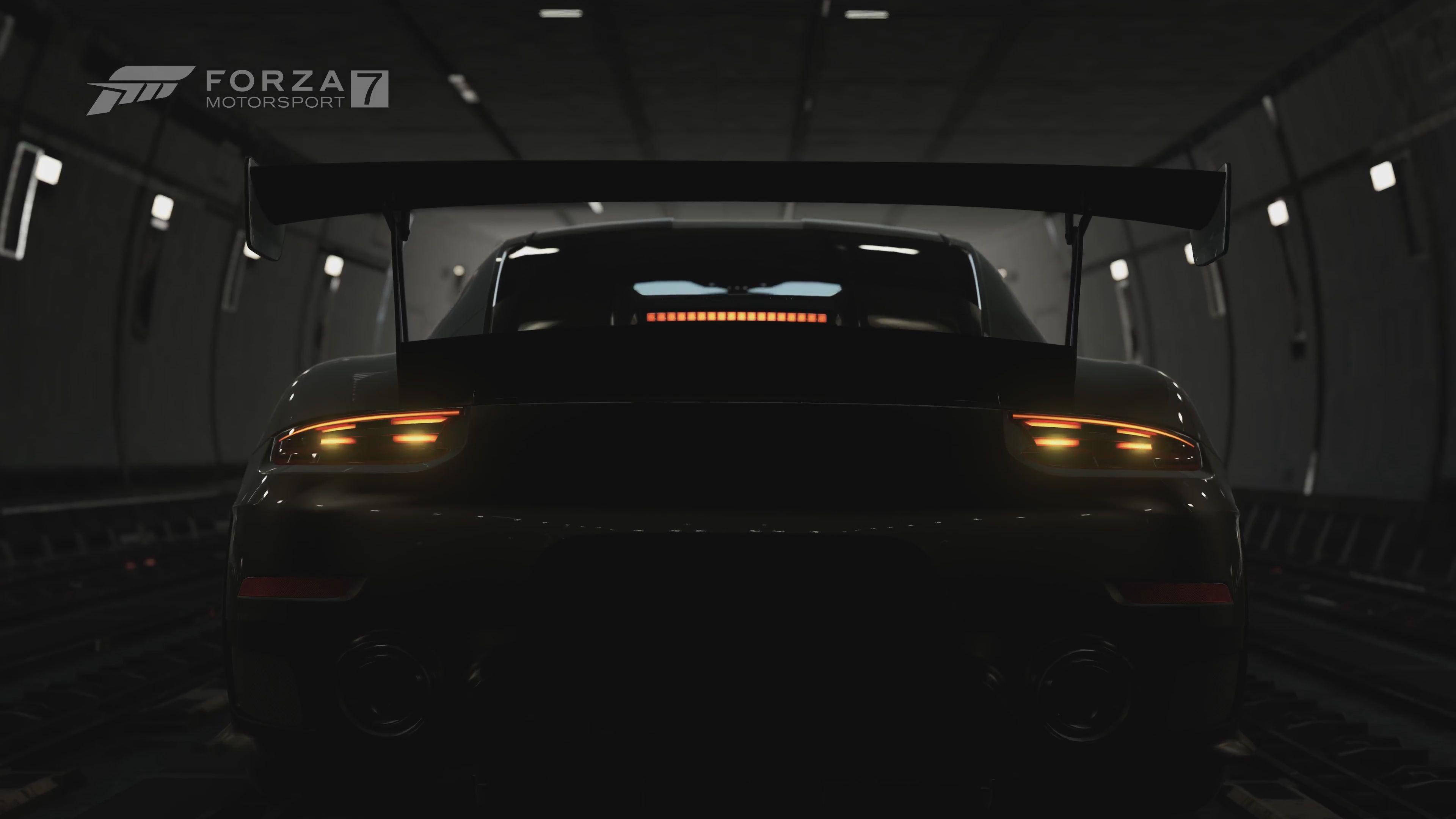 Silhouette 桌布 壁紙 — 一架流線型黑色賽車，帶有發光的橙色尾燈，在昏暗的隧道中蓄勢待發，準備高速馳騁。