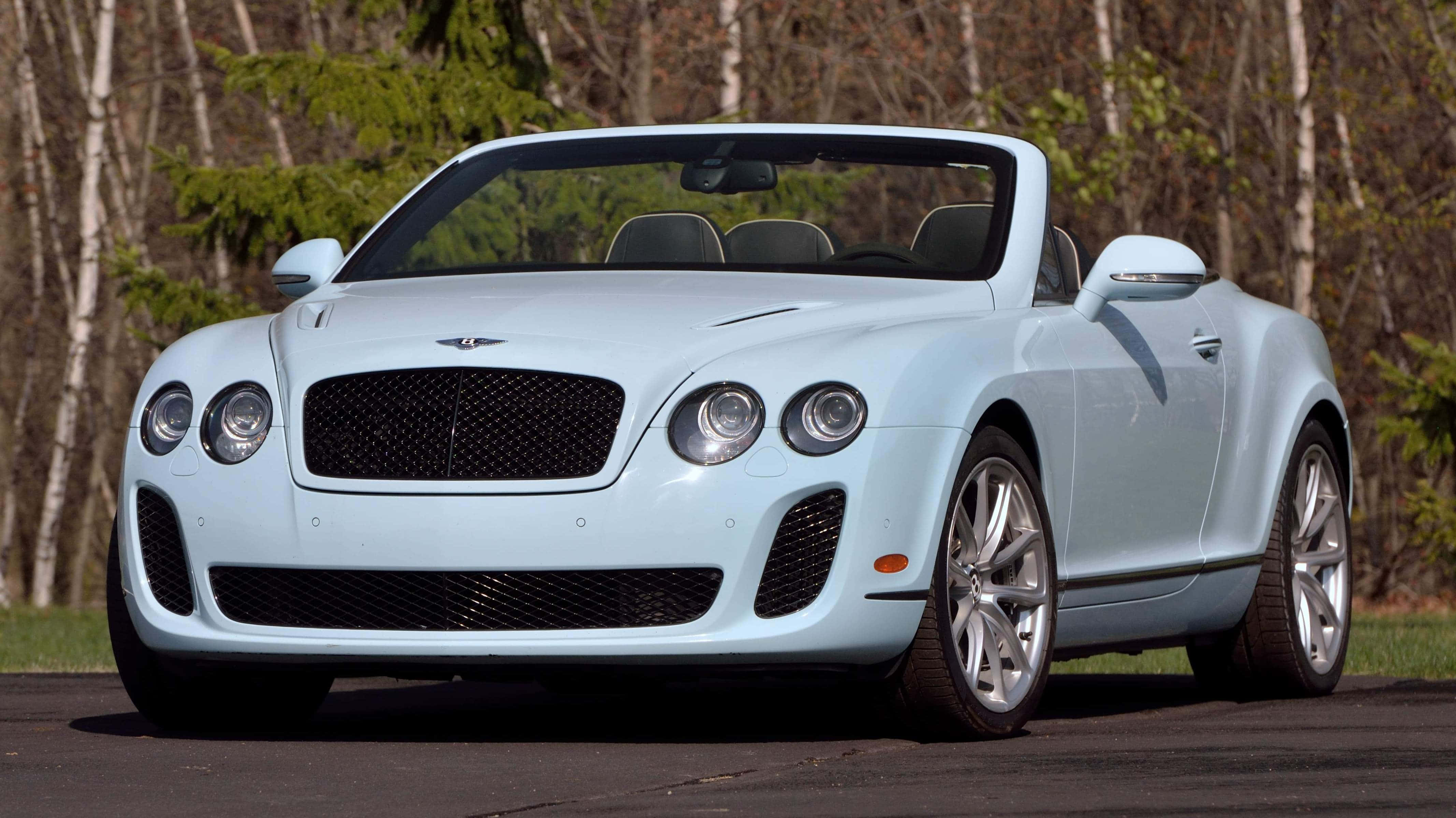 Bentley Continental Supersports 桌布 壁紙 — 一架淺藍色賓利開篷車停泊在瀝青路上，背景有樹木。