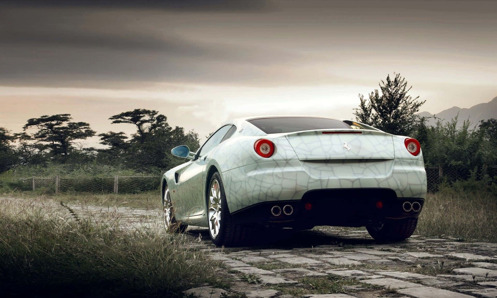 Ferrari 599 Gtb Fiorano 桌布 壁紙 — 一架白色法拉利跑車帶有裂紋油漆，停泊在鄉間田野的石徑上，天空多雲。