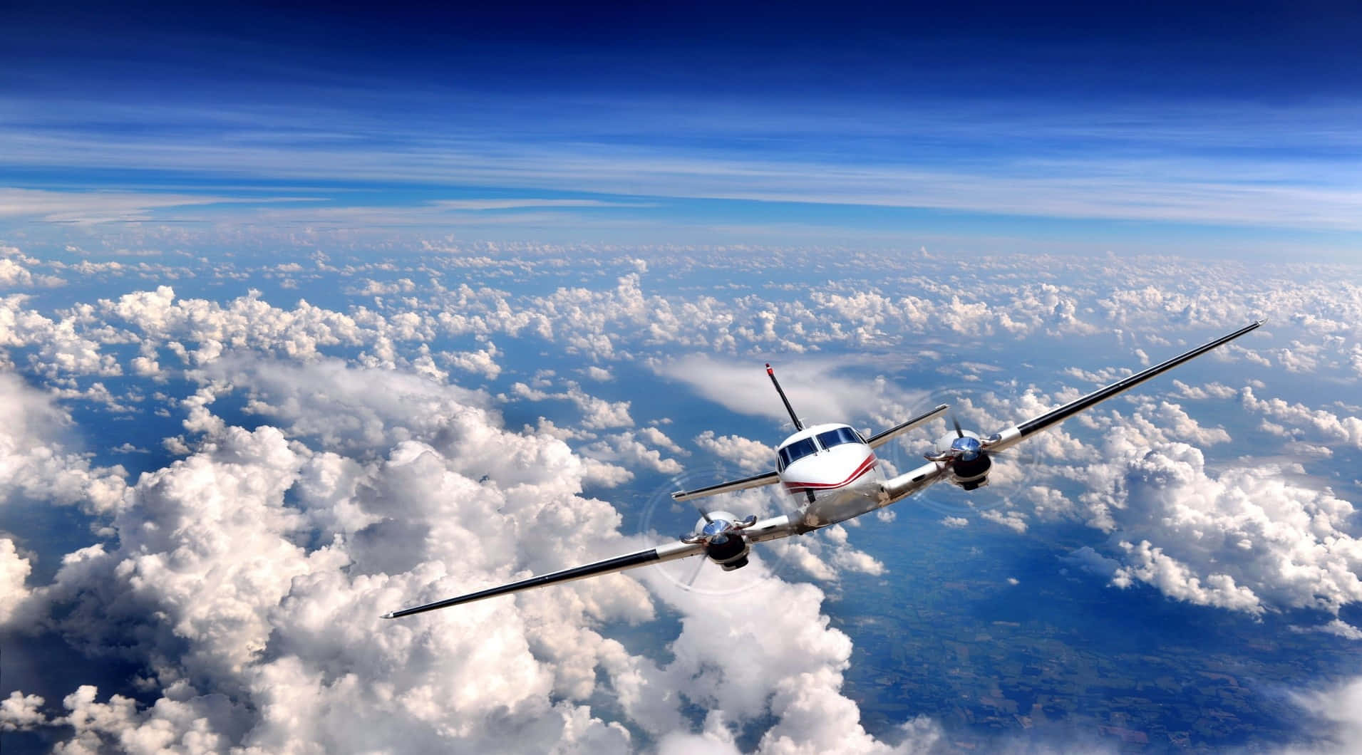 Aviation 桌布 壁紙 — 一架白色螺旋槳飛機在鮮豔的藍天下翱翔於蓬鬆的白雲之上。