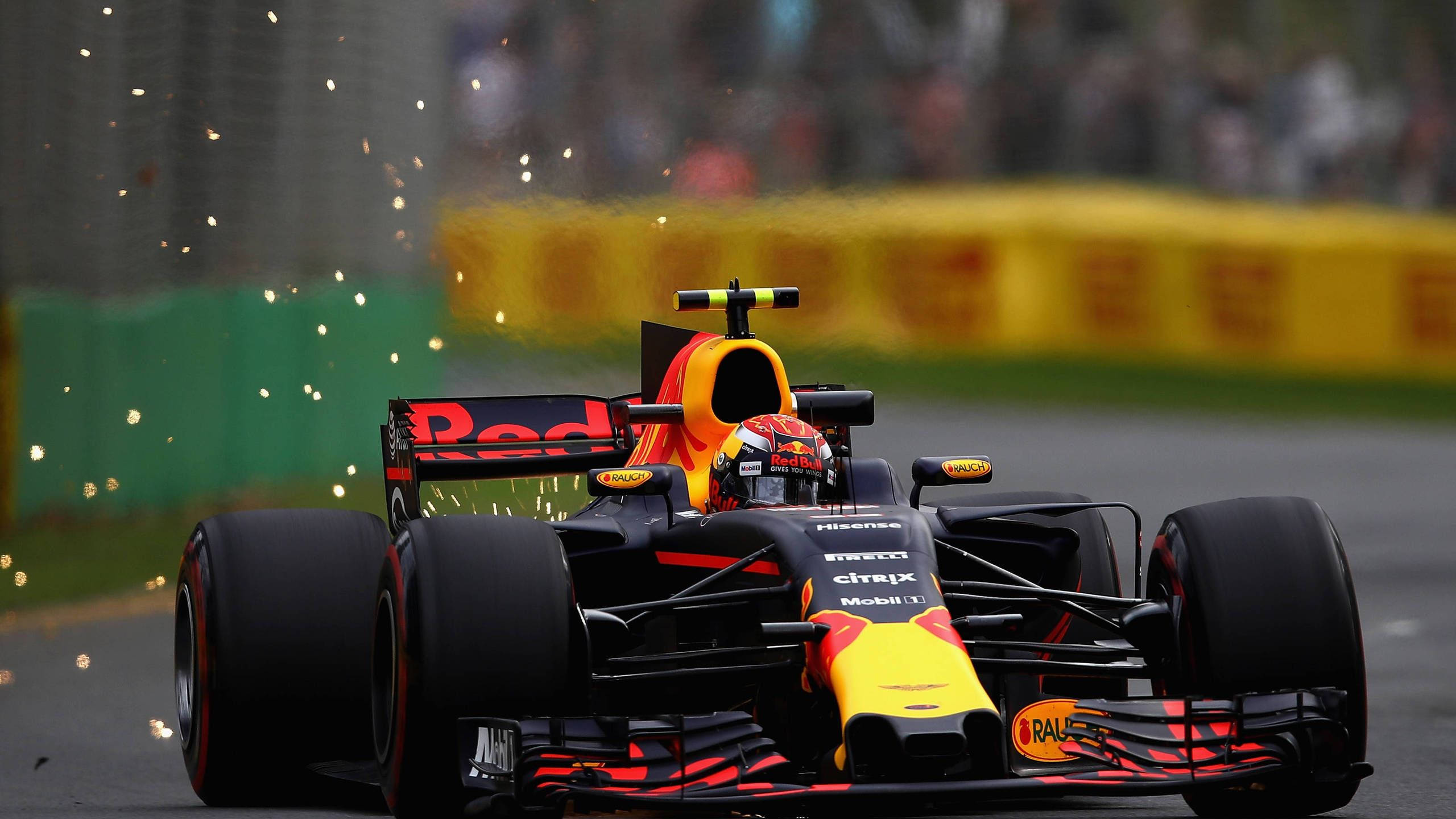 Verstappen 桌布 壁紙 — 一架紅牛一級方程式賽車在賽道上奔馳，火花四濺，背景是模糊的觀眾。