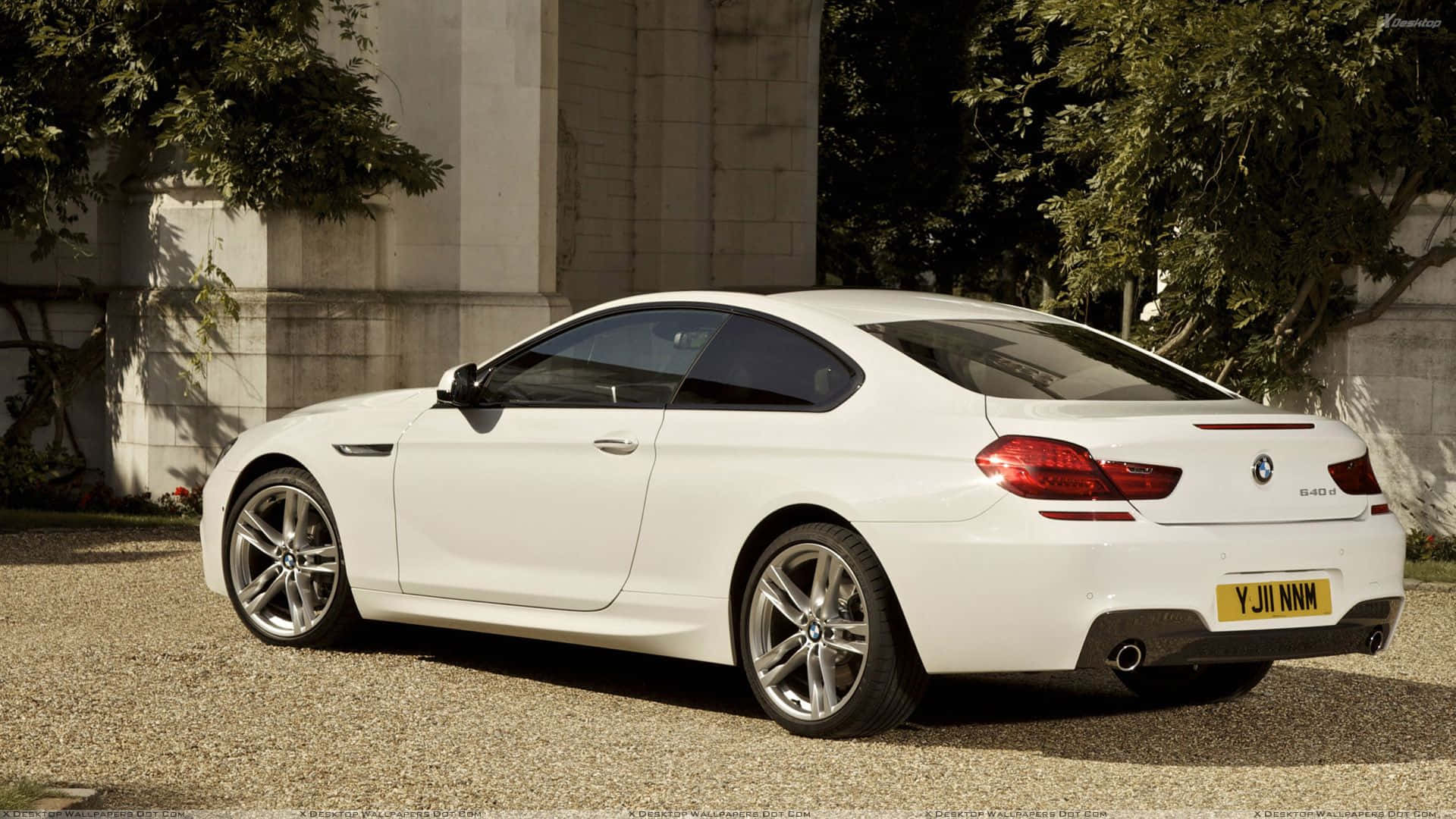 Bmw 6 Series 桌布 壁紙 — 一架純白色BMW 6系雙門轎跑車停泊在碎石路上，旁邊是石建築物和茂密的綠樹。