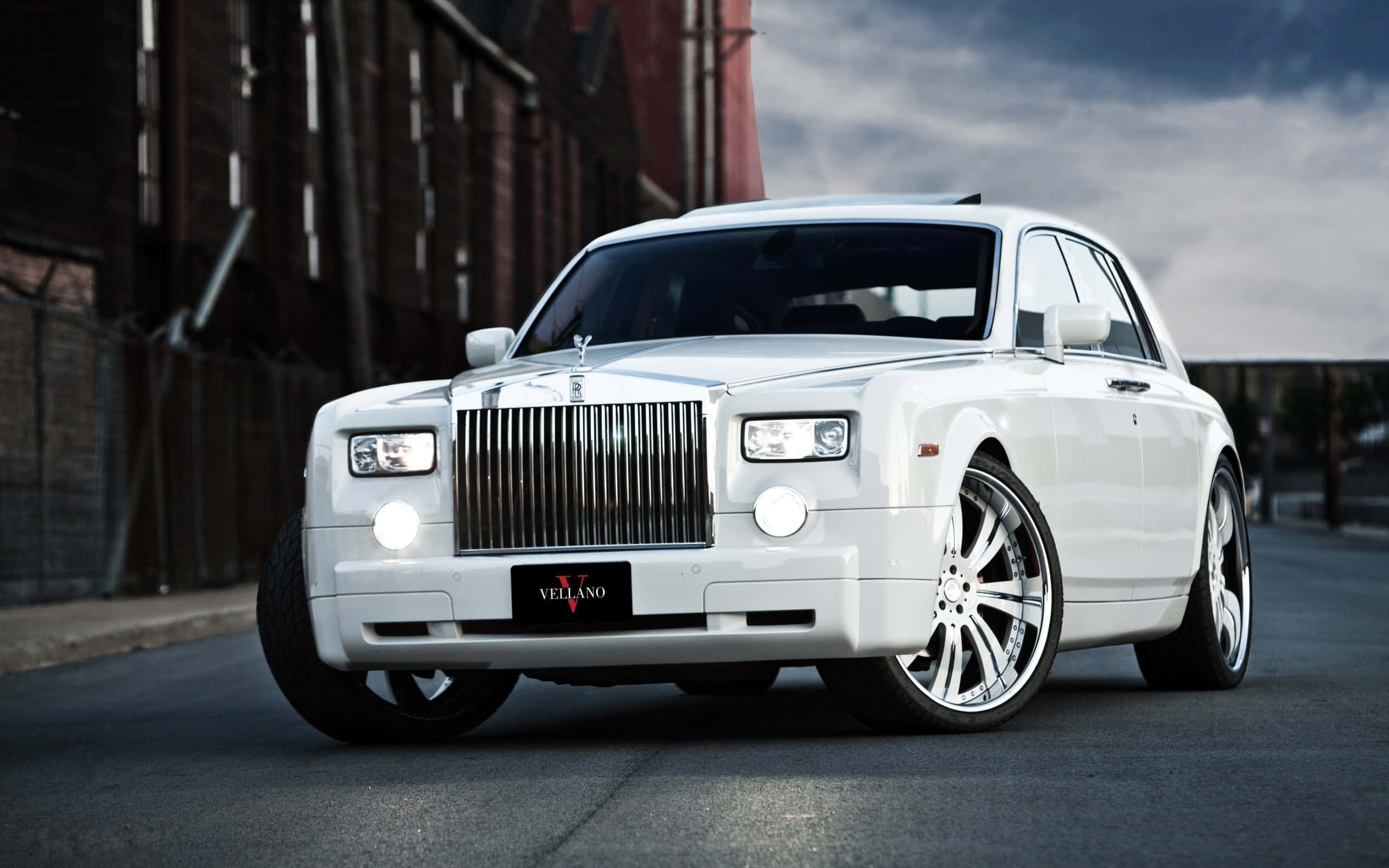 Rolls Royce 桌布 壁紙 — 一架純白色的勞斯萊斯幻影配備定制輪圈，停泊在陰天下的城市街道上。