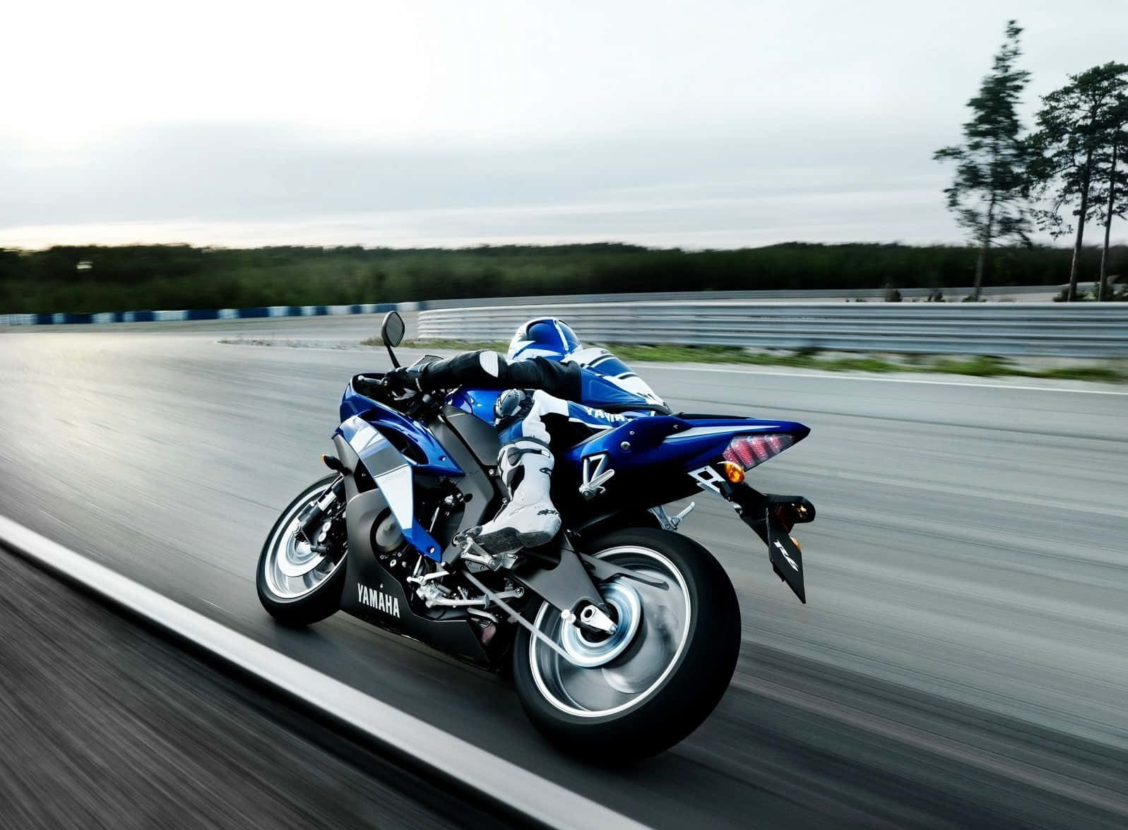 機車 桌布 壁紙 — 一架藍色Yamaha跑車在賽道上傾斜入彎，動態模糊傳達高速與精準。