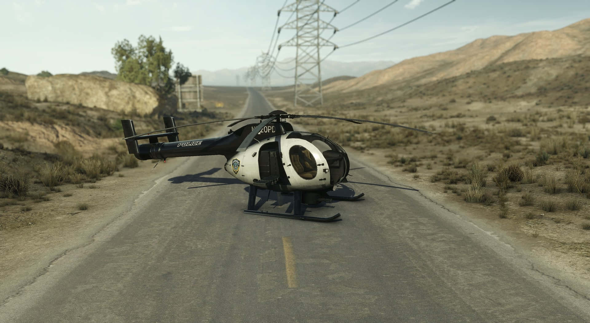 Battlefield Vehicles 桌布 壁紙 — 一架警用直升機停泊在荒蕪的沙漠道路上，背景有電線和遠山，天空晴朗。
