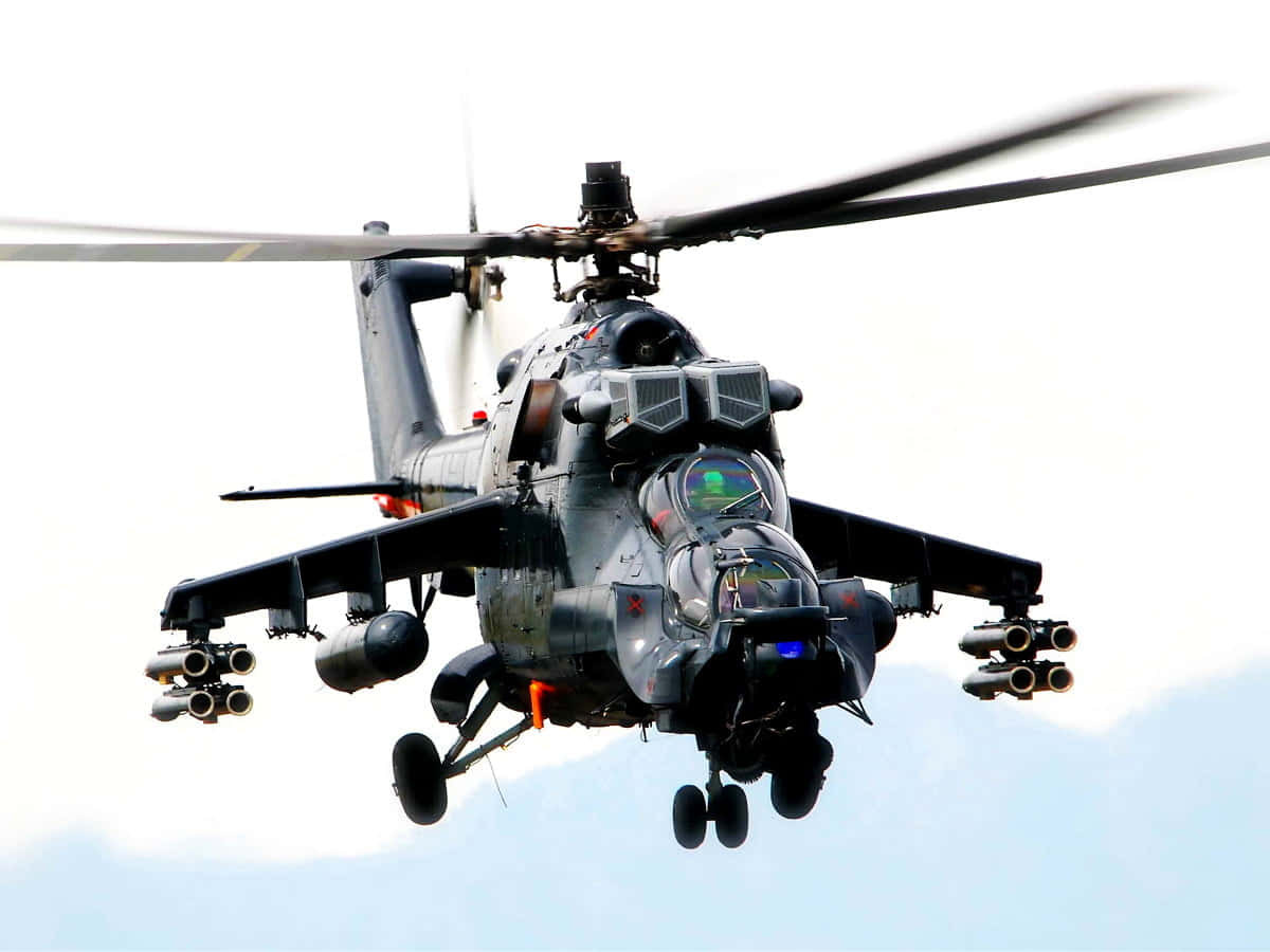 空軍 桌布 壁紙 — 一架軍用攻擊直升機在明亮的天空下低飛，旋翼槳葉模糊，武器清晰可見。