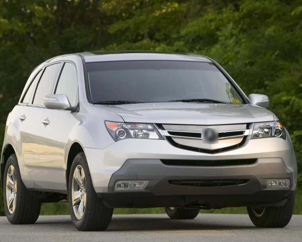 Acura Mdx 桌布 壁紙 — 一架銀色Acura MDX SUV停泊在行人路上，背景有茂密的綠色樹木。