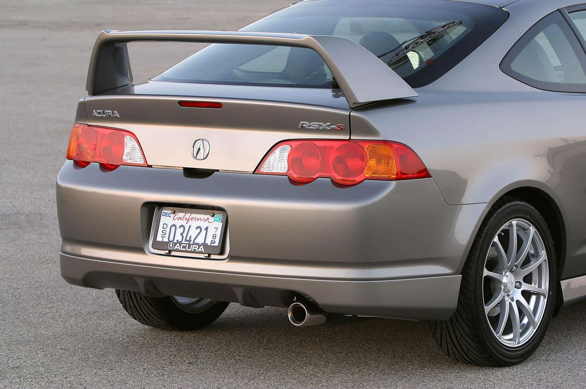 Rsx Type-s 桌布 壁紙 — 一架銀色Acura RSX-S運動轎跑車停在瀝青路上，帶有後擾流板和加州車牌。