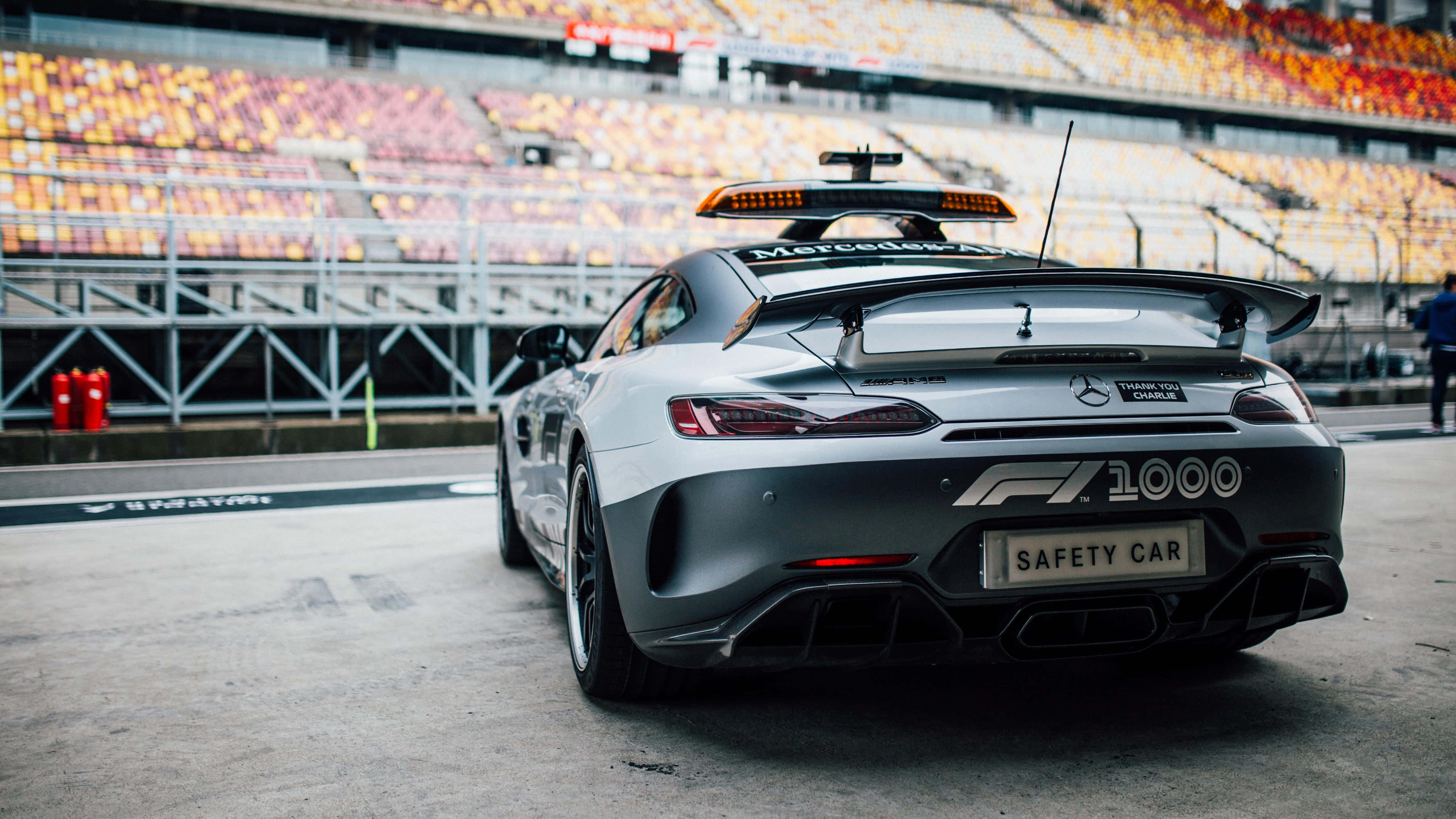 Safety Car 桌布 壁紙 — 一架銀色平治AMG GT R安全車，帶有「F1 1000」和「SAFETY CAR」貼紙，停在賽道上，背景是空無一人的看台。