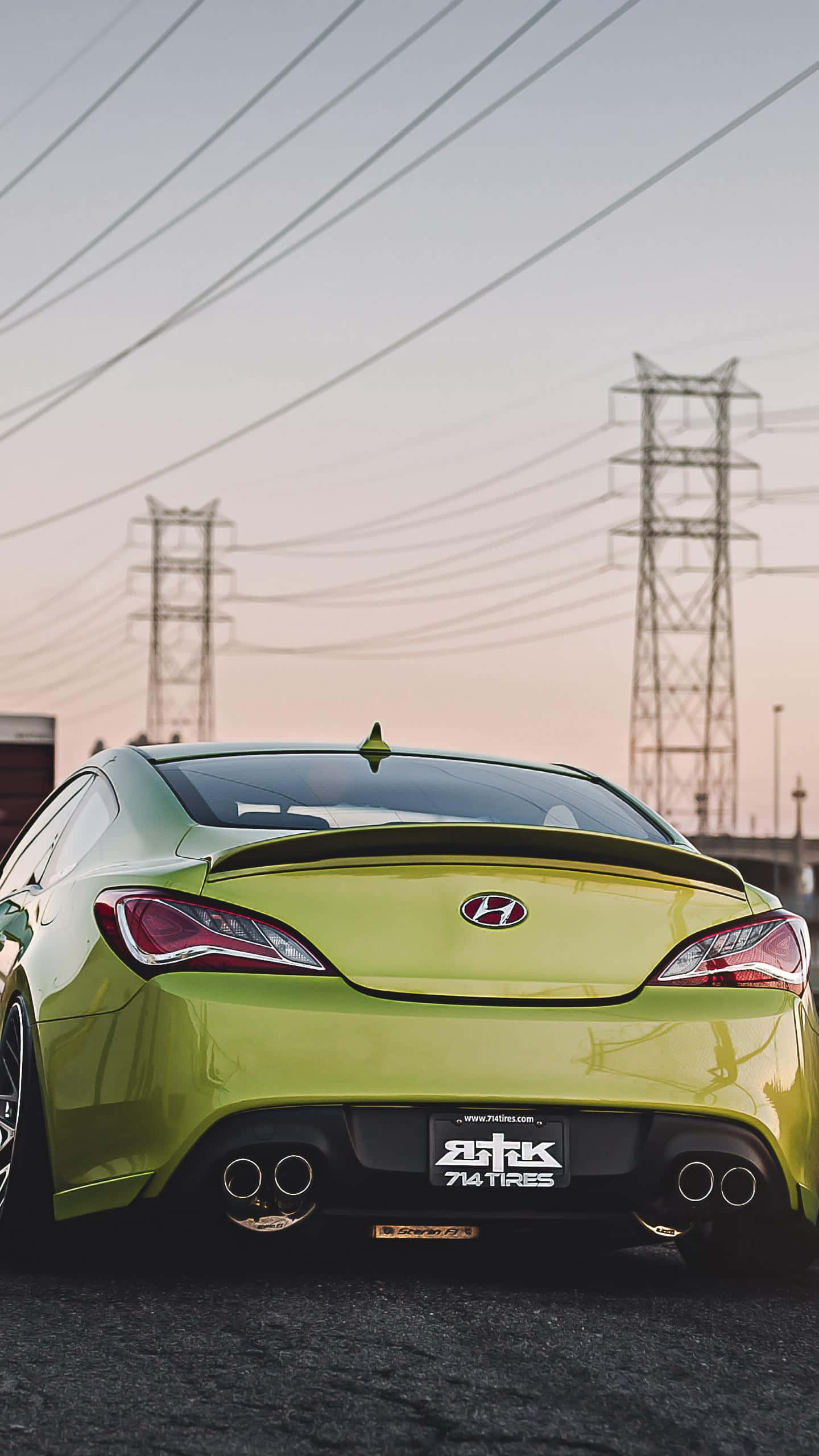 Hyundai Genesis 桌布 壁紙 — 一架青檸綠色的現代跑車，配備雙出排氣管，在日落時分停泊在電線下。