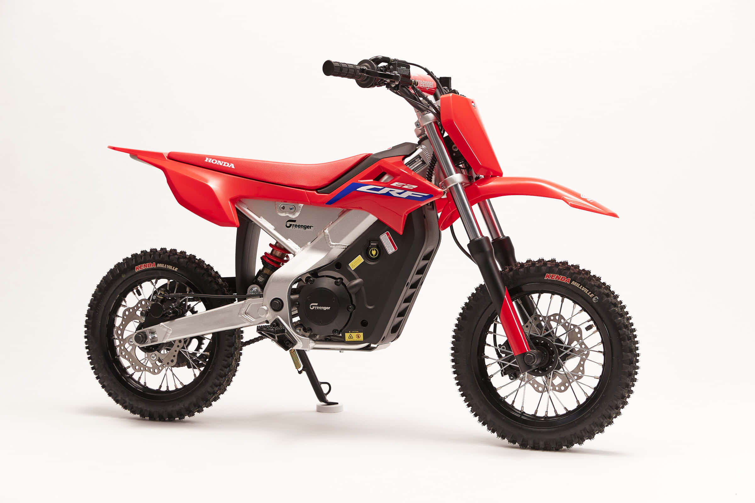 Dirtbike 桌布 壁紙 — 一架鮮紅色嘅Honda CRF電動越野電單車企喺潔白嘅工作室地板上，展示佢嘅粗輪胎同流線型現代設計。