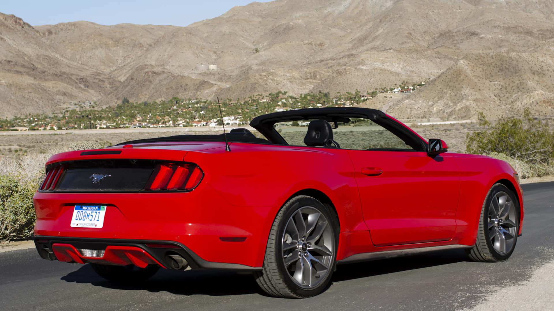 Ford Mustang Ecoboost 桌布 壁紙 — 一架鮮紅色開篷跑車停泊在沙漠公路上，背景是崎嶇的山脈。