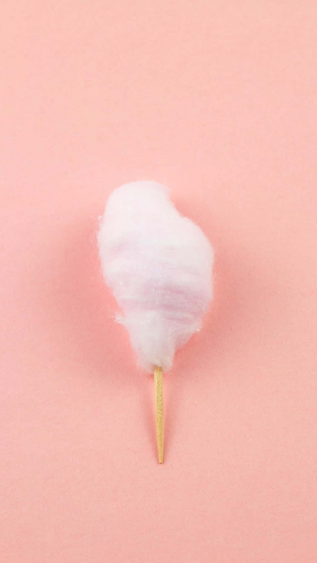 Cotton Candy 桌布 壁紙 — 一根木棍上單一 fluffy 粉紅色棉花糖，背景為柔和粉彩粉紅色。