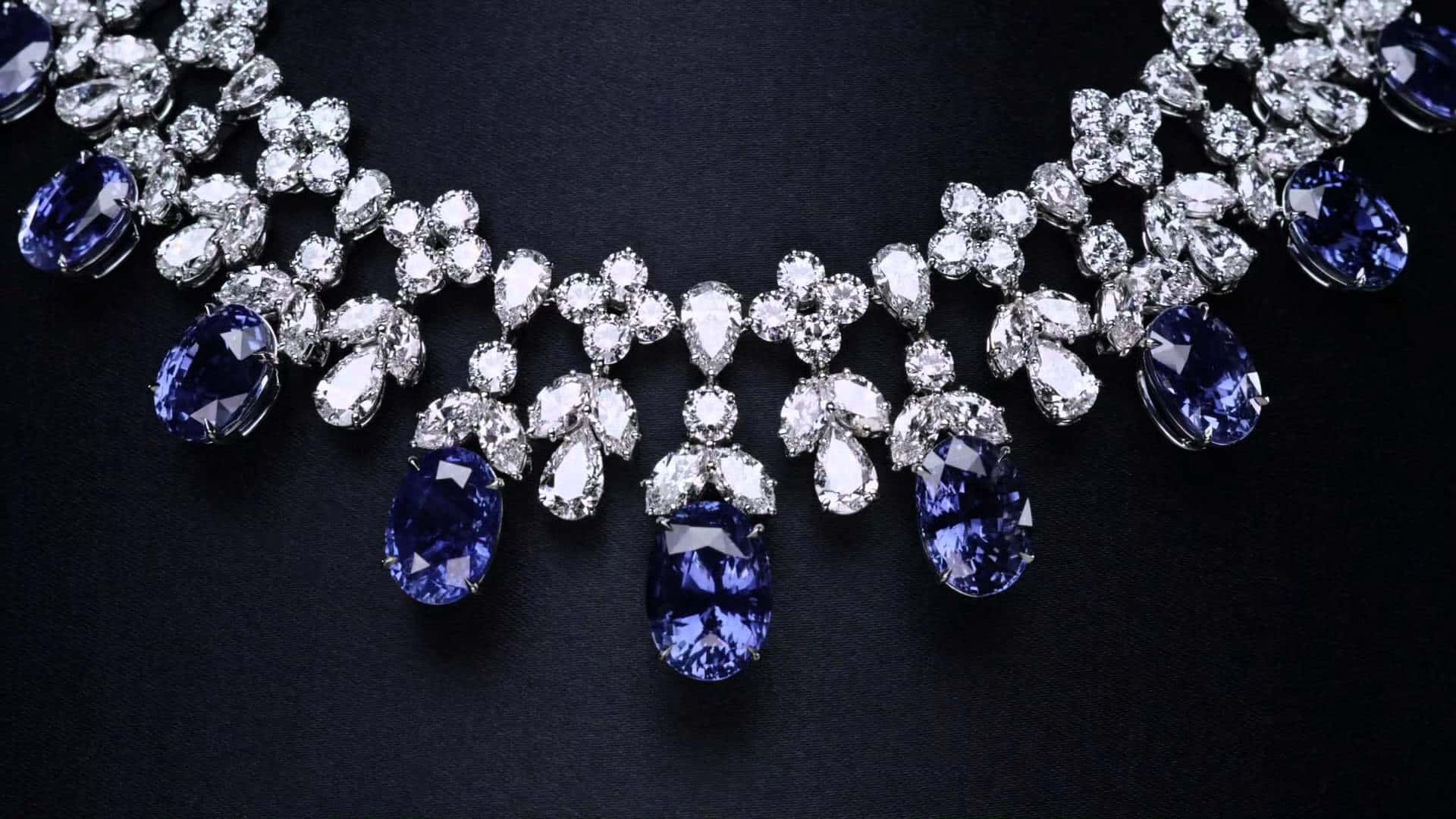 Jewelry Design 桌布 壁紙 — 一條令人驚嘆的項鍊，鑲有深藍色藍寶石和閃閃發光的鑽石，以黑色天鵝絨為背景。