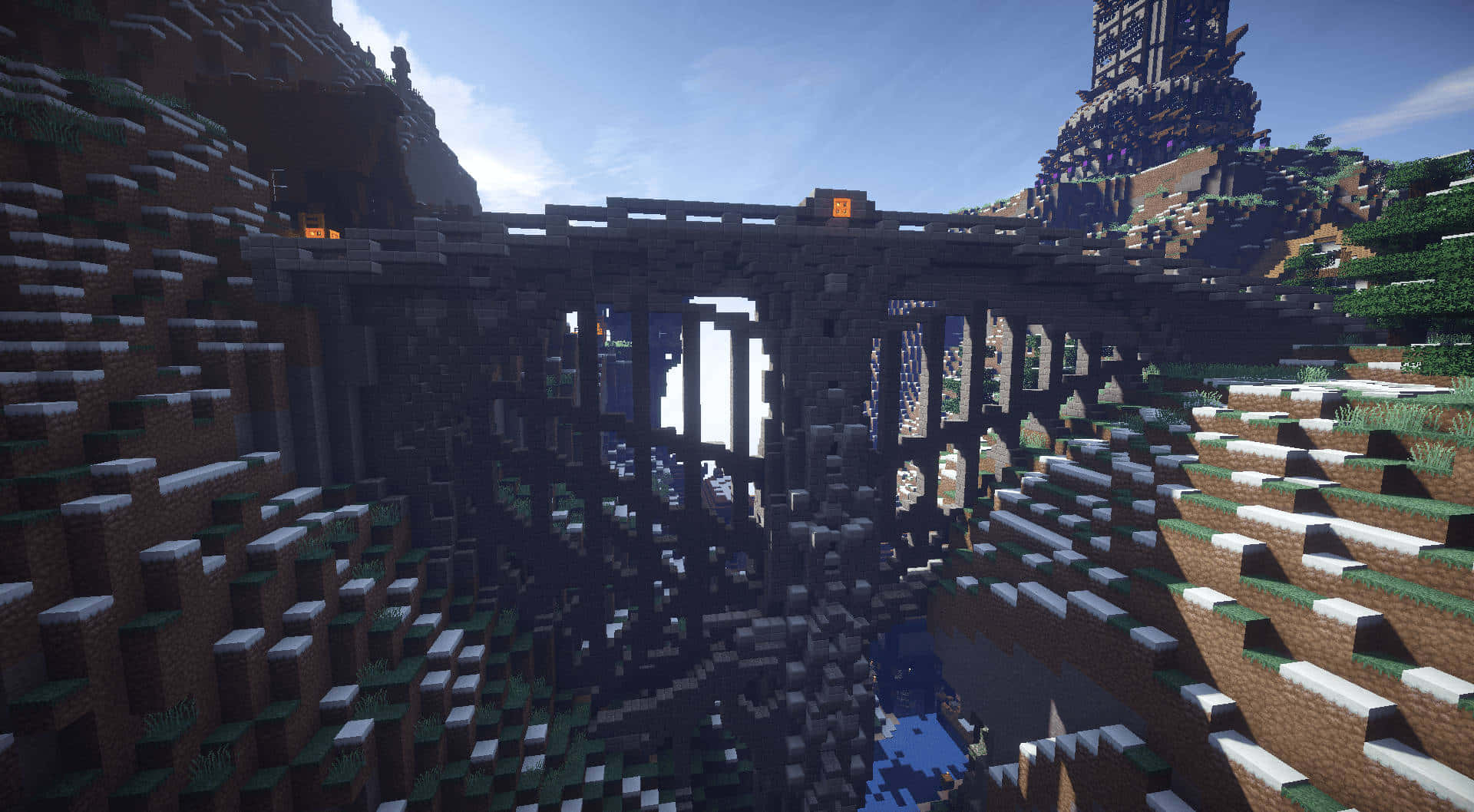 Minecraft Bridges 桌布 壁紙 — 一條像素化的Minecraft橋樑橫跨一個深峽谷，兩旁有草坡，下方有河流，在清澈的藍天下。