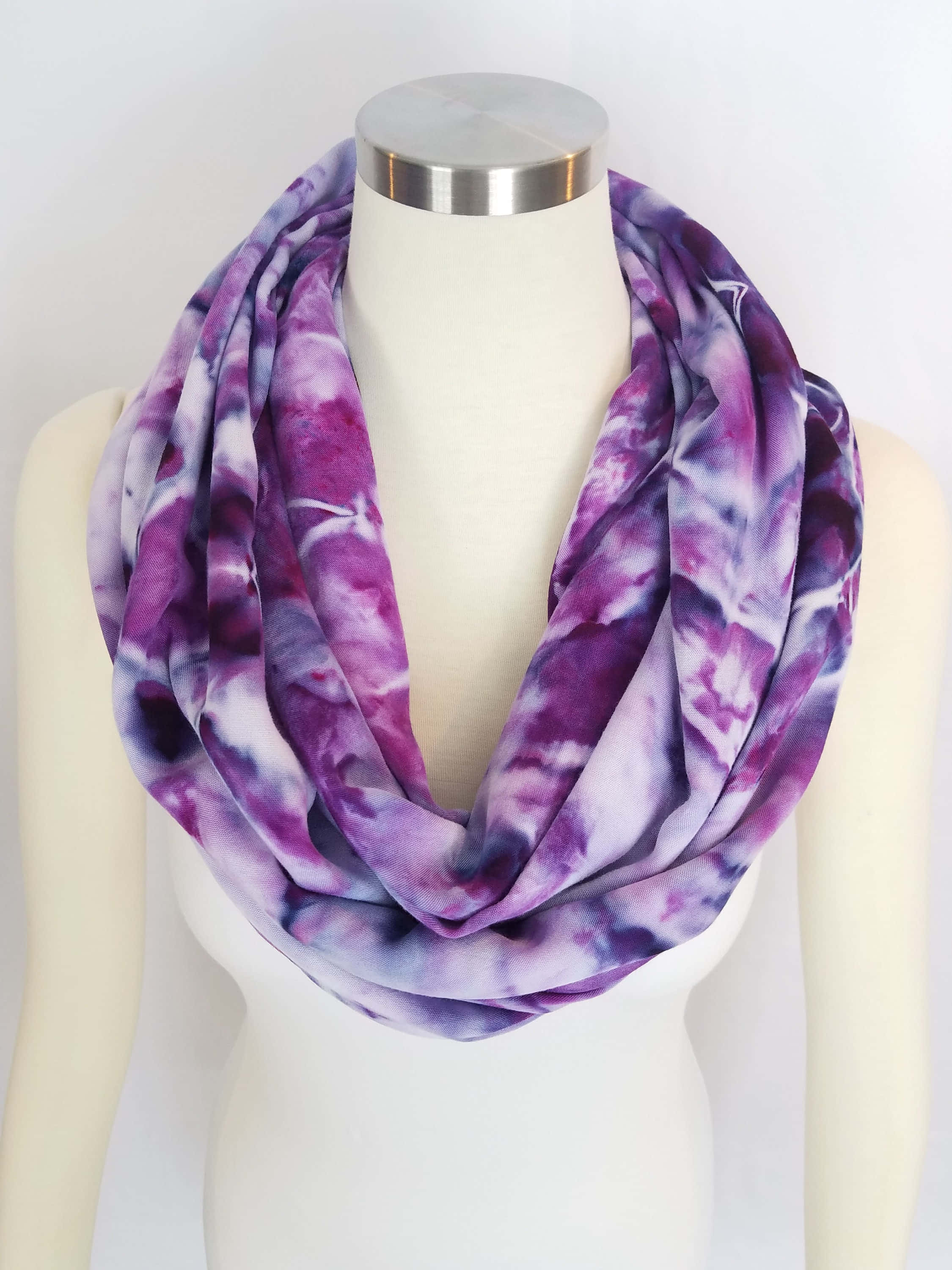 Purple Scarf 桌布 壁紙 — 一條充滿活力的紫色和白色紮染無限圍巾，優雅地披在人體模型頸部，背景為潔淨的白色。