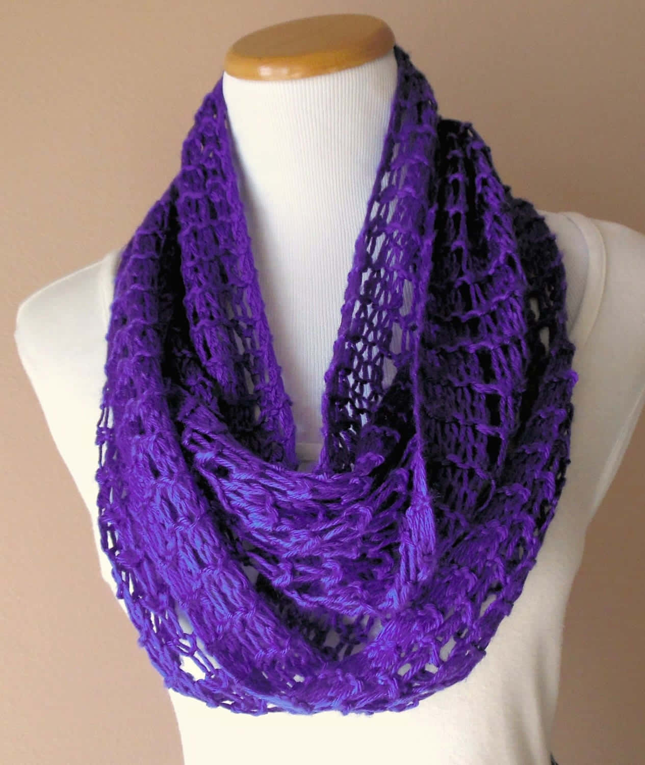 Purple Scarf 桌布 壁紙 — 一條充滿活力的紫色鉤針編織無限圍巾，帶有漸變至深紫色，優雅地披在白色模特兒半身像上。