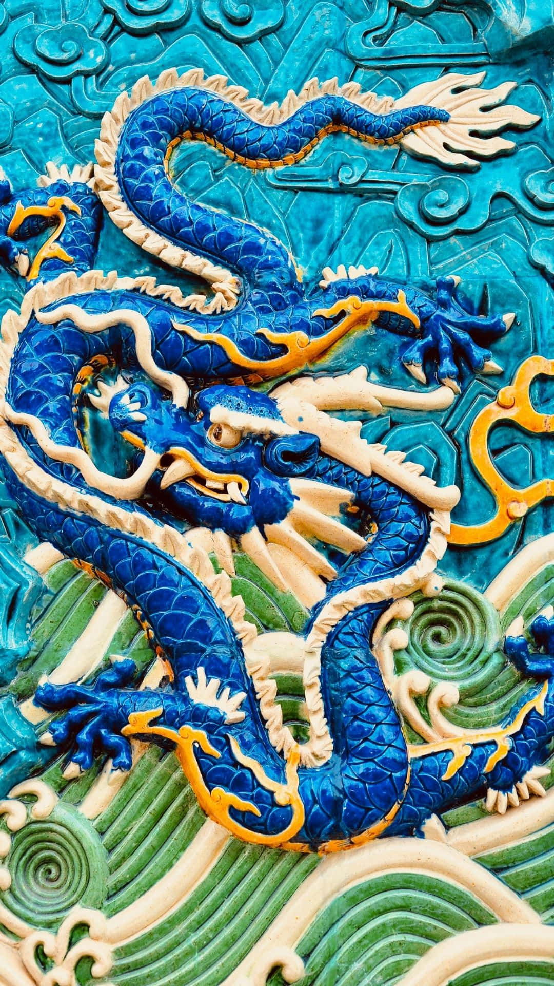 Blue Dragon 桌布 壁紙 — 一條充滿活力的藍色龍，帶有金色點綴，動態地盤繞在藍綠色和綠色的華麗浮雕背景上。