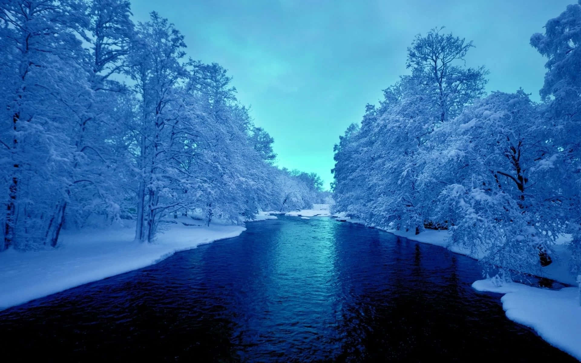 Twitter Header 桌布 壁紙 — 一條寧靜的冬日河流在白雪覆蓋的樹木間流淌，天空是涼爽的藍色暮光。
