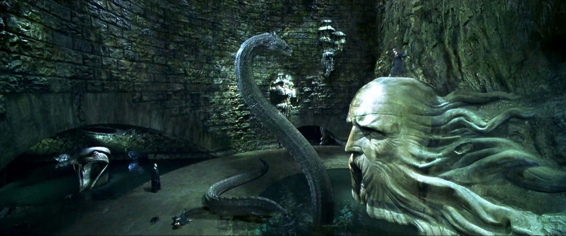 Harry Potter Basilisk 桌布 壁紙 — 一條巨大的石蛇和一個巨大的雕刻面孔在黑暗潮濕的地牢中聳立，火炬閃爍不定。