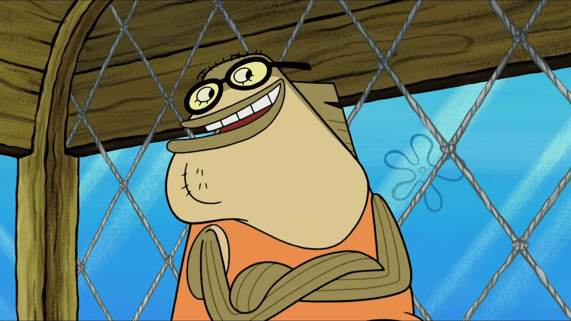 Bubble Bass 桌布 壁紙 — 一條戴眼鏡、穿橙色恤衫的開心卡通魚，在木屋頂下的鐵絲網圍欄後面微笑。