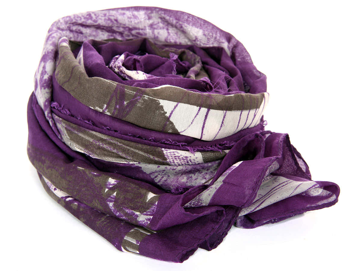 Purple Scarf 桌布 壁紙 — 一條柔軟的紫色圍巾，帶有白色和灰色的幾何圖案，鬆散地盤繞在純白色背景上。