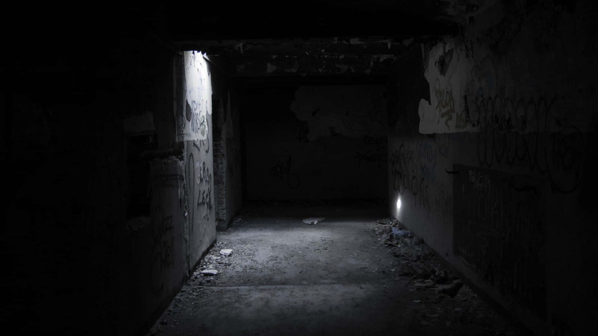 Unsettling 桌布 壁紙 — 一條狹窄廢棄的混凝土隧道，牆上有塗鴉，盡頭破窗透出微弱光線。