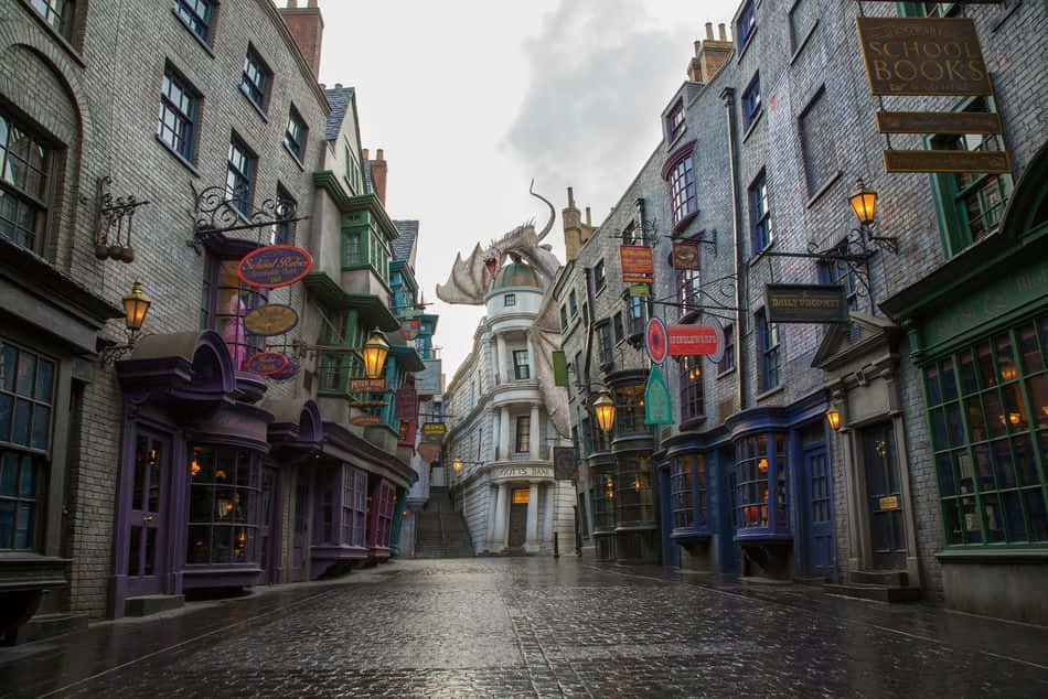 Diagon Alley 桌布 壁紙 — 一條狹窄的鵝卵石街道，兩旁是色彩繽紛的巫師商店，陰天，上方有一條龍雕像聳立。