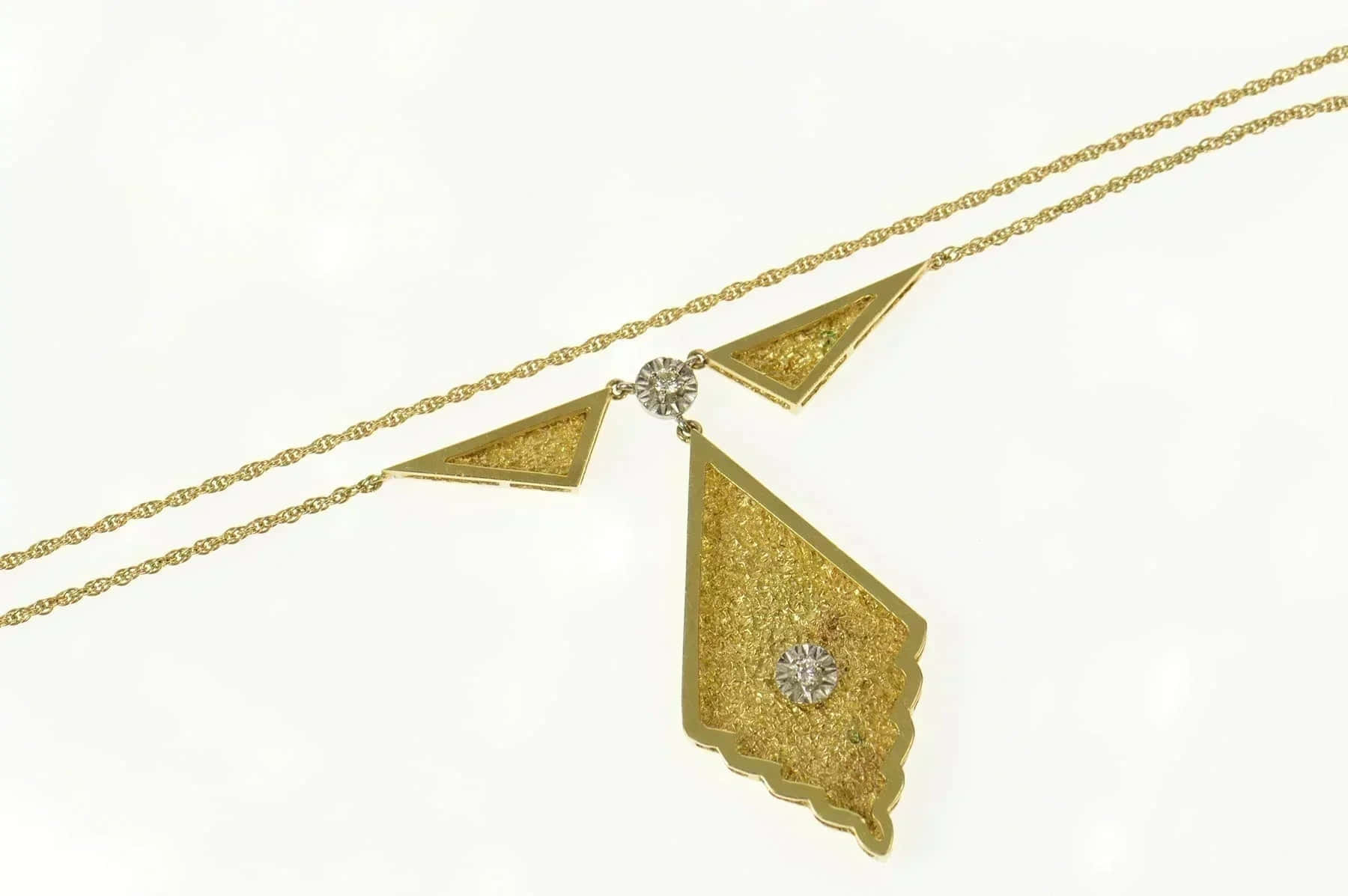 Yellow Triangle 桌布 壁紙 — 一條精緻的金色項鍊，帶有幾何三角形吊墜和閃爍的鑽石，襯托在潔淨的白色背景上。