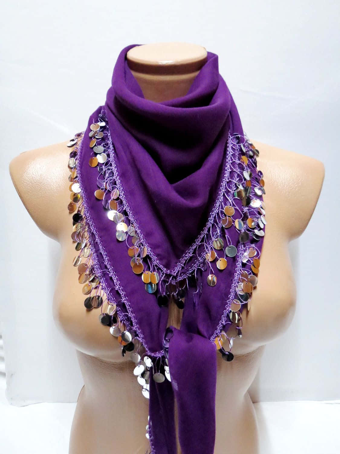 Purple Scarf 桌布 壁紙 — 一條華麗的紫色圍巾，飾有閃爍的金屬硬幣，優雅地披在白色背景前的模特兒半身像上。
