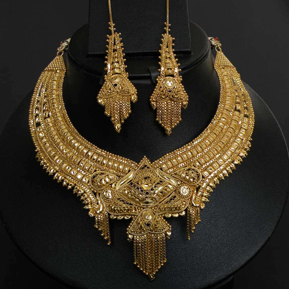 Jewelry Design 桌布 壁紙 — 一條華麗的金項鍊和配套的耳環，帶有精緻的鏤空花絲和垂墜珠子，展示在黑色模特兒半身像上。